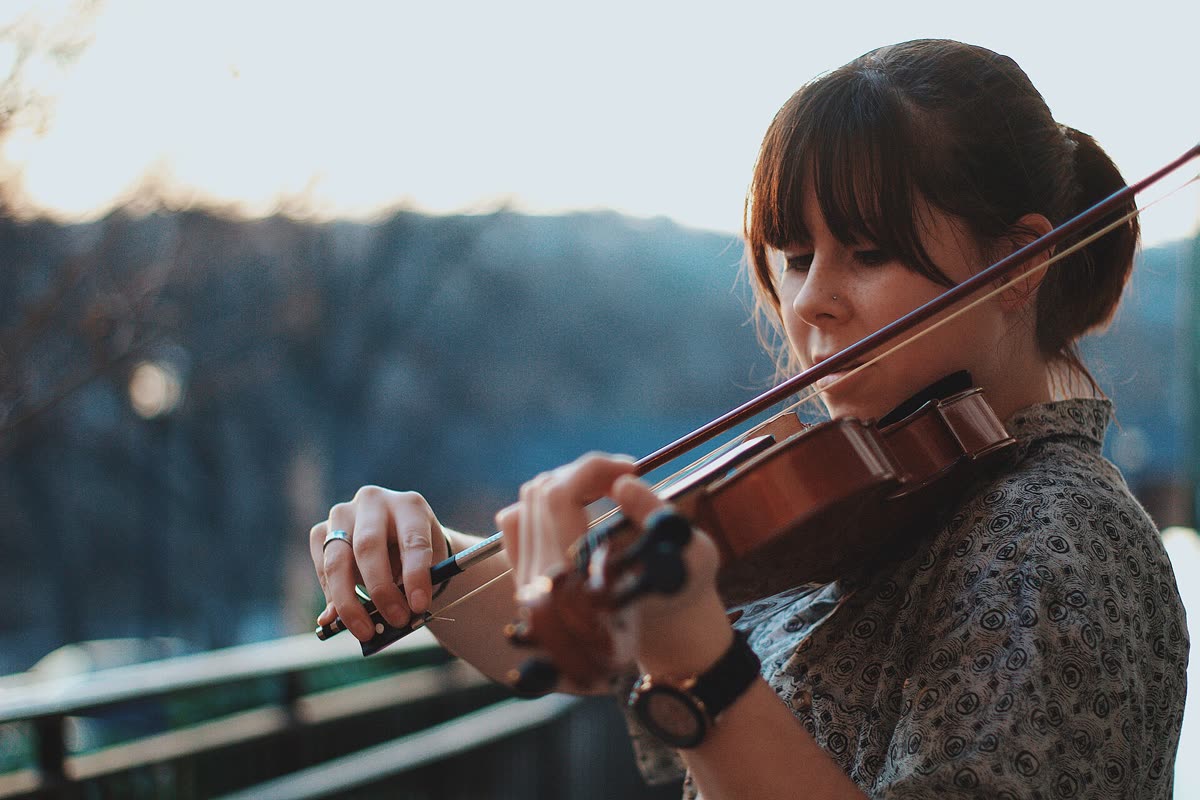 Una ragazza studia il violino sul balcone di casa