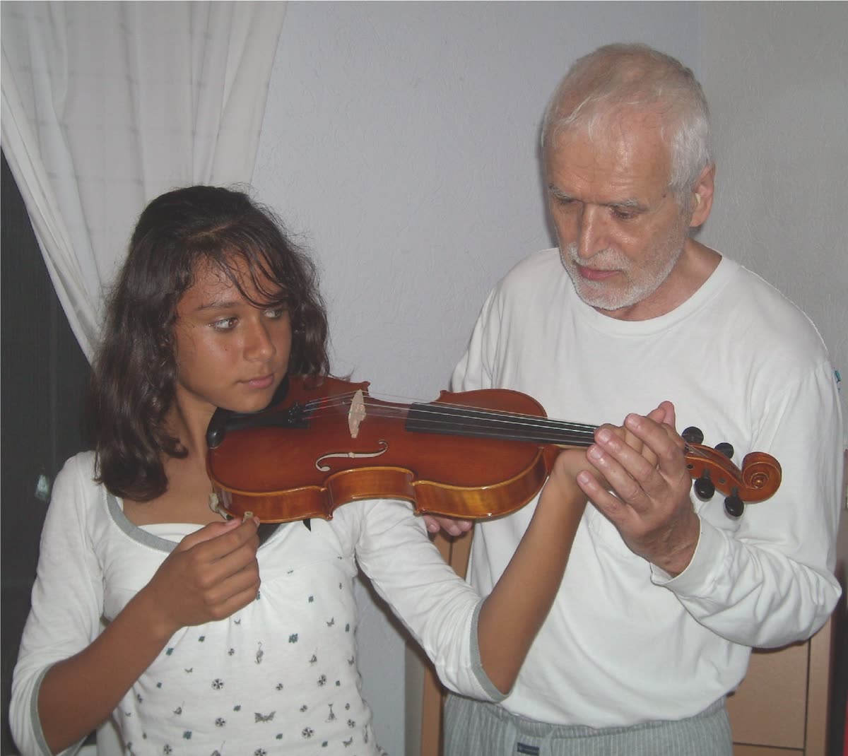 Un insegnante sistema la posizione del violino di una ragazza